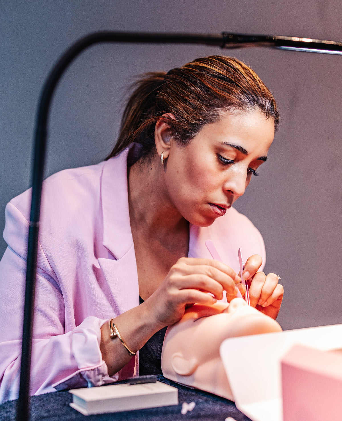 Cursist oefent volume wimperextensions op een oefenhoofd – Extension Bar Academy cursus in person
