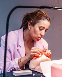 Cursist oefent volume wimperextensions op een oefenhoofd – Extension Bar Academy cursus in person
